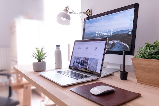 macbook on table beside white imac