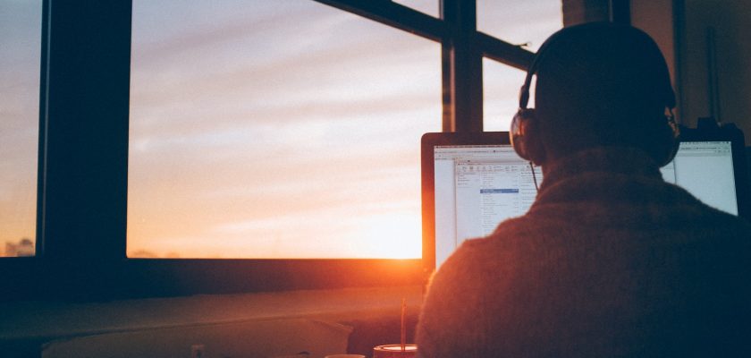 man sitting facing monitor
