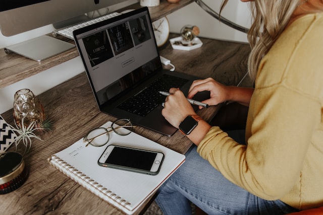 person in blue denim jeans using macbook