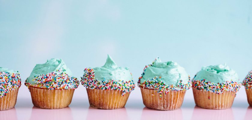 six teal icing cupcakes with sprinkles